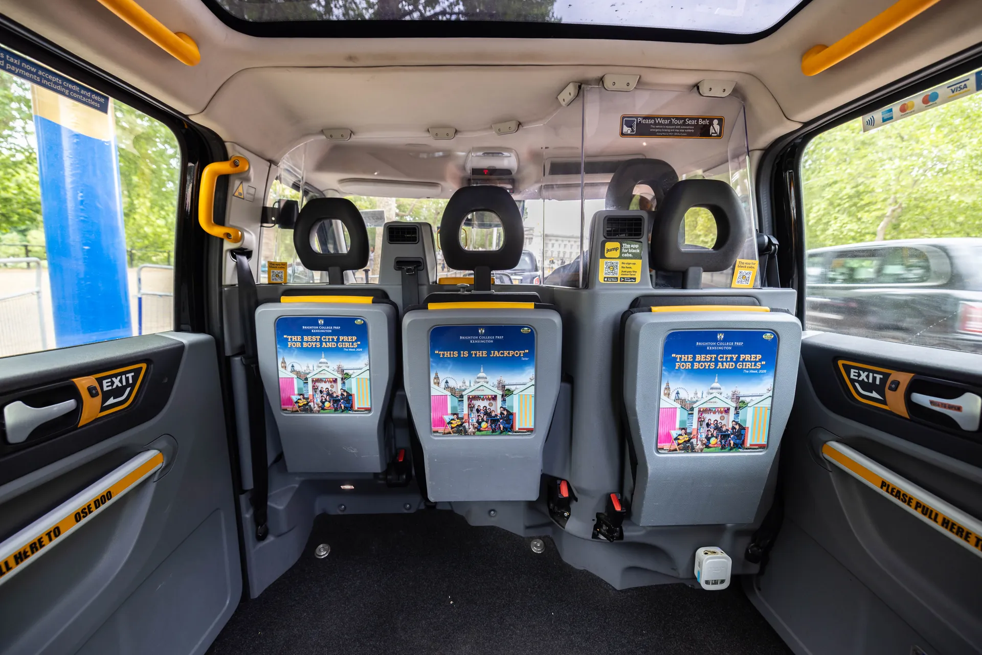 Passenger compartment of a taxi with three rear-facing tip seats and a glass roof