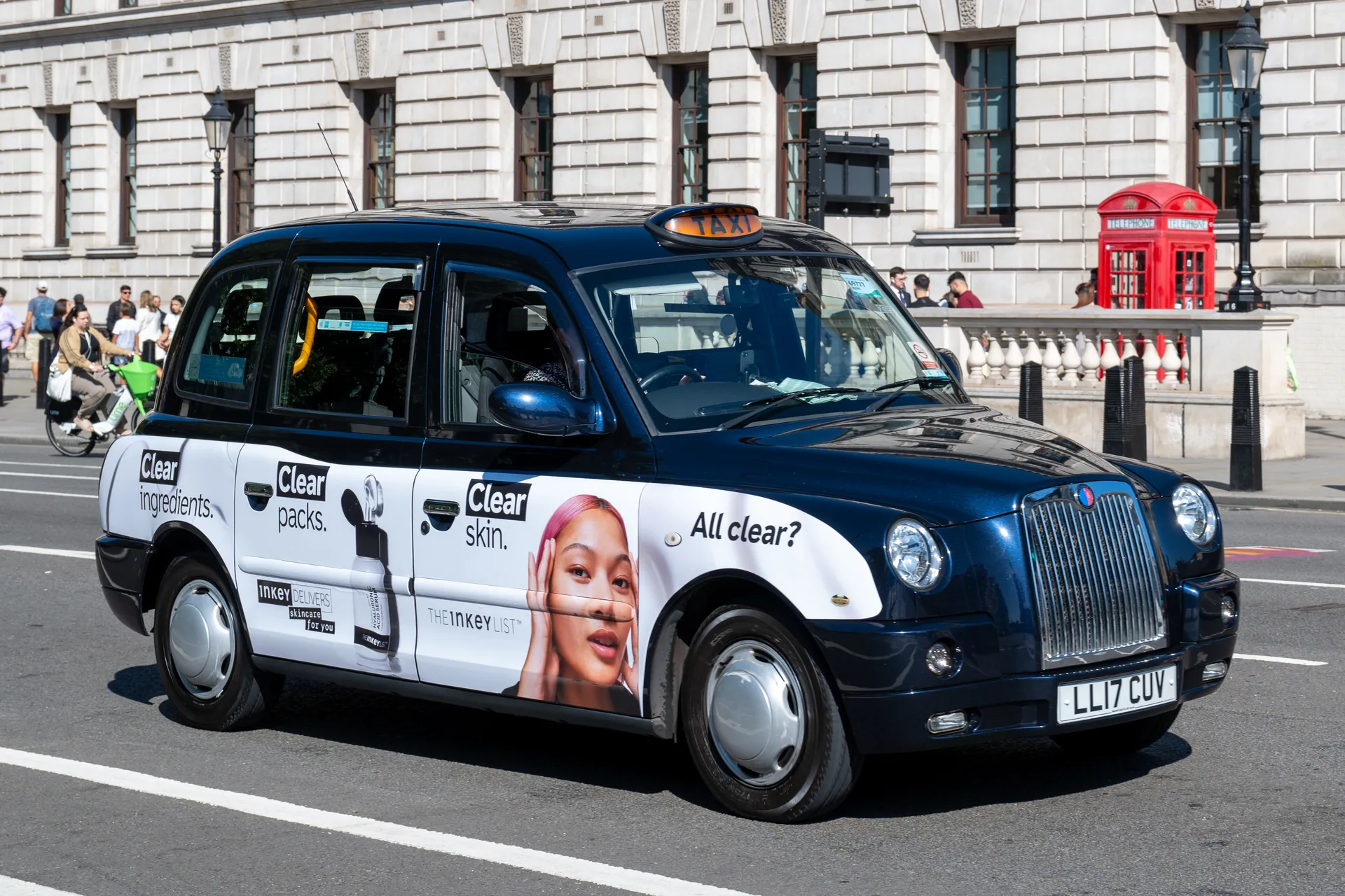 Black taxi with white The Inkey List skincare advertising along its side